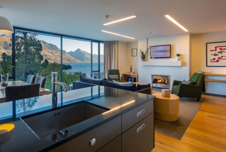 living area with fireplace and views in queenstown accommodation 768x516