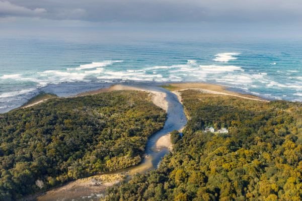 Aerial view of Waitutu Forest Lodge, unique off-grid accommodation deep in the heart of Fiordland National Park, Southland.