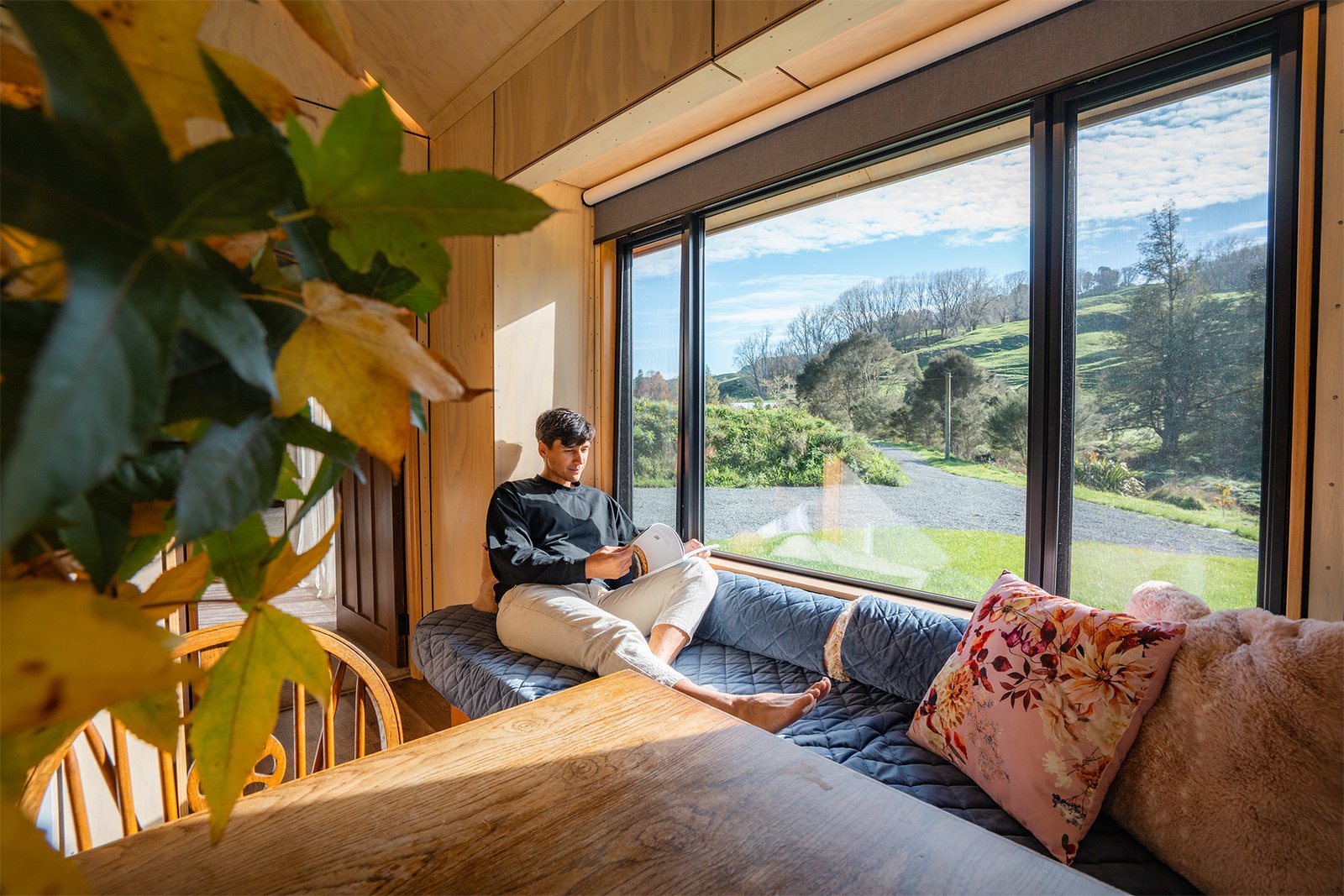 guest relaxing inside ripples retreat cabin with countryside views waikato