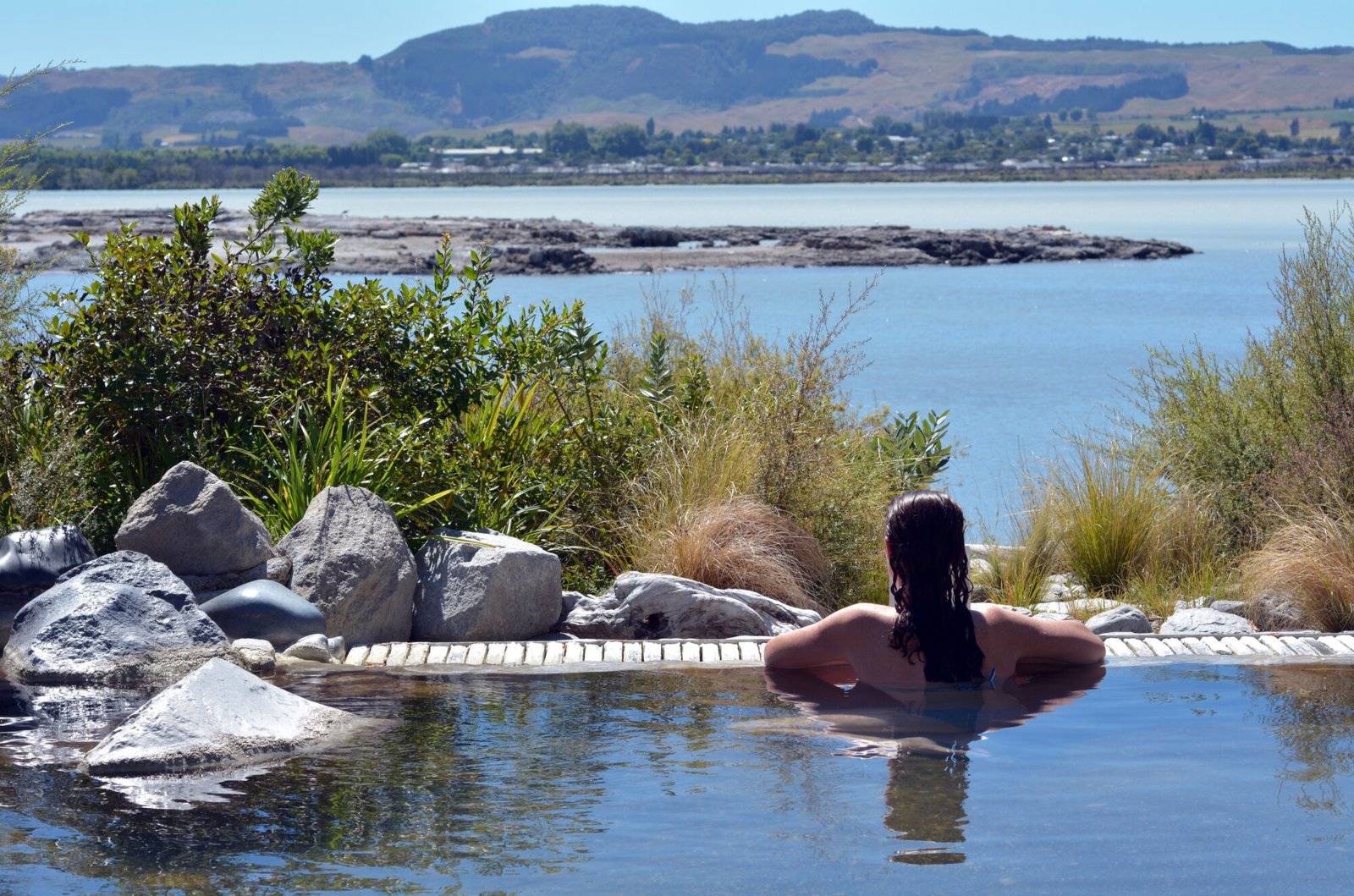 Relaxing in hot pools overlooking a lake in the Bay of Plenty New Zealand