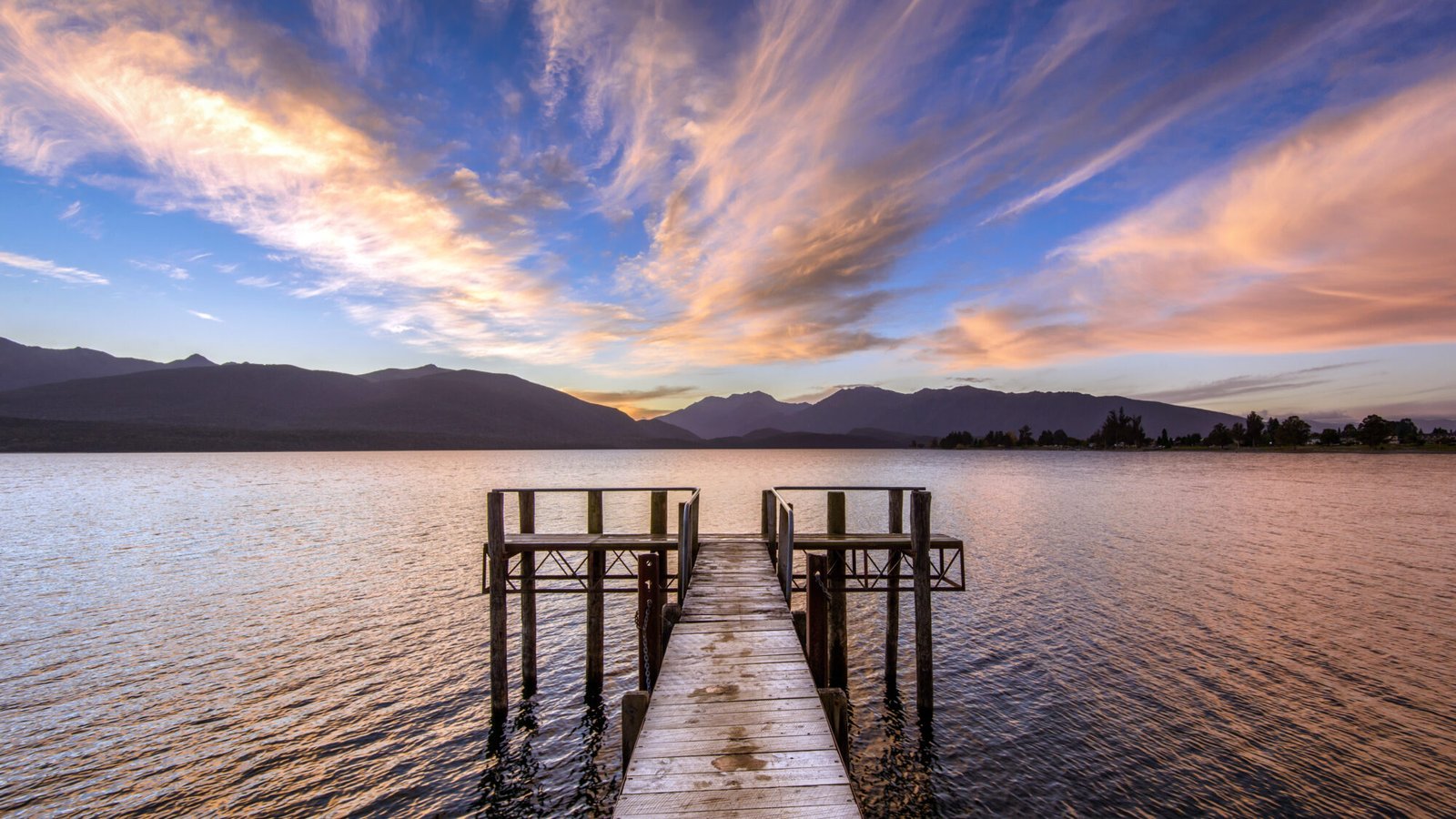 Sunset over Lake Te Anau in Fiordland, a popular stop on a South Island winter road trip