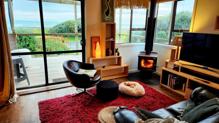 piha sunset bach lounge fireplace ocean view 768x432